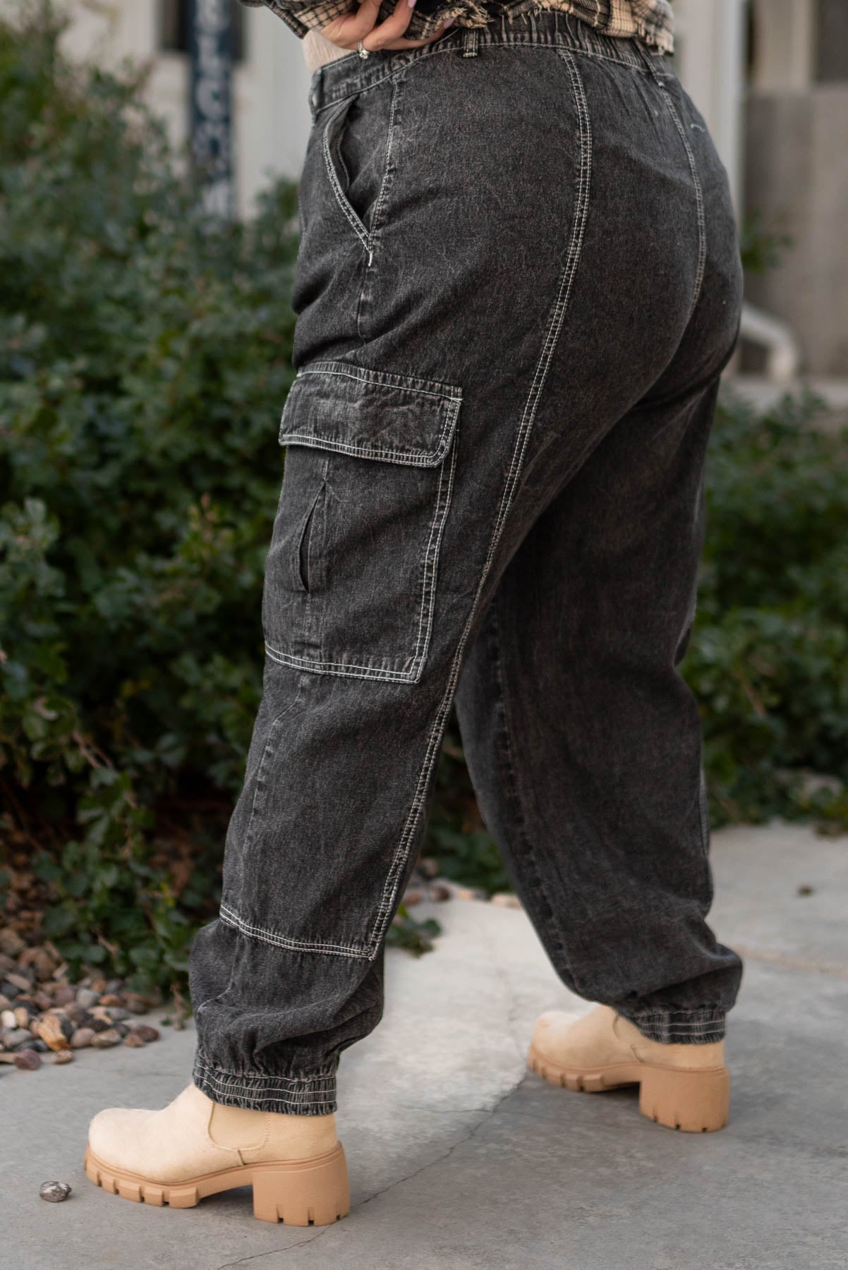 Side view of plus size black cargo parachute pants