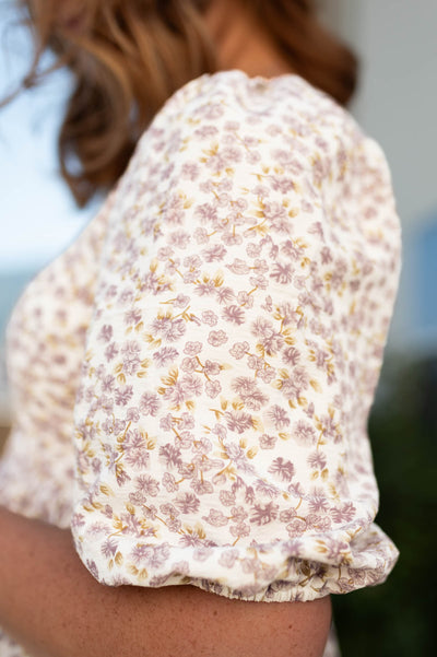 The sleeve of a ivory floral dress