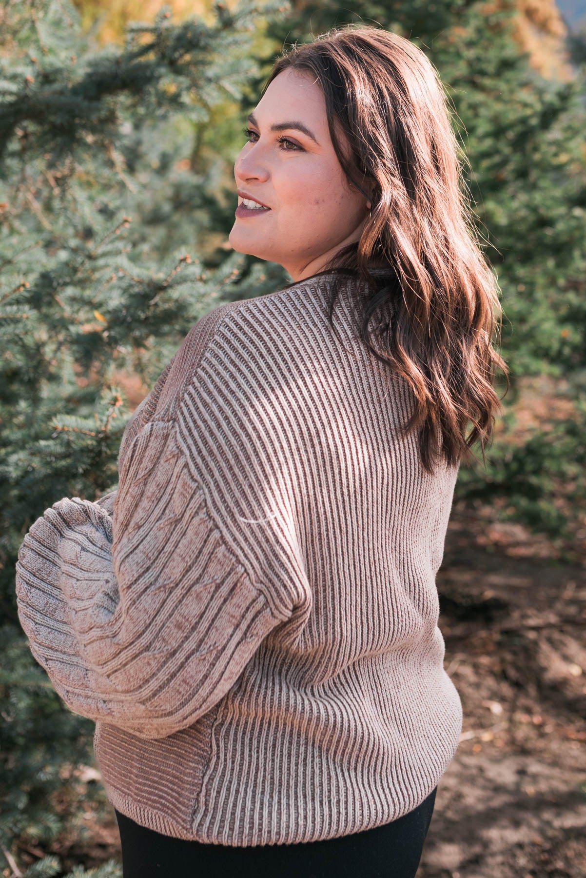 Side view of a plus size taupe sweater