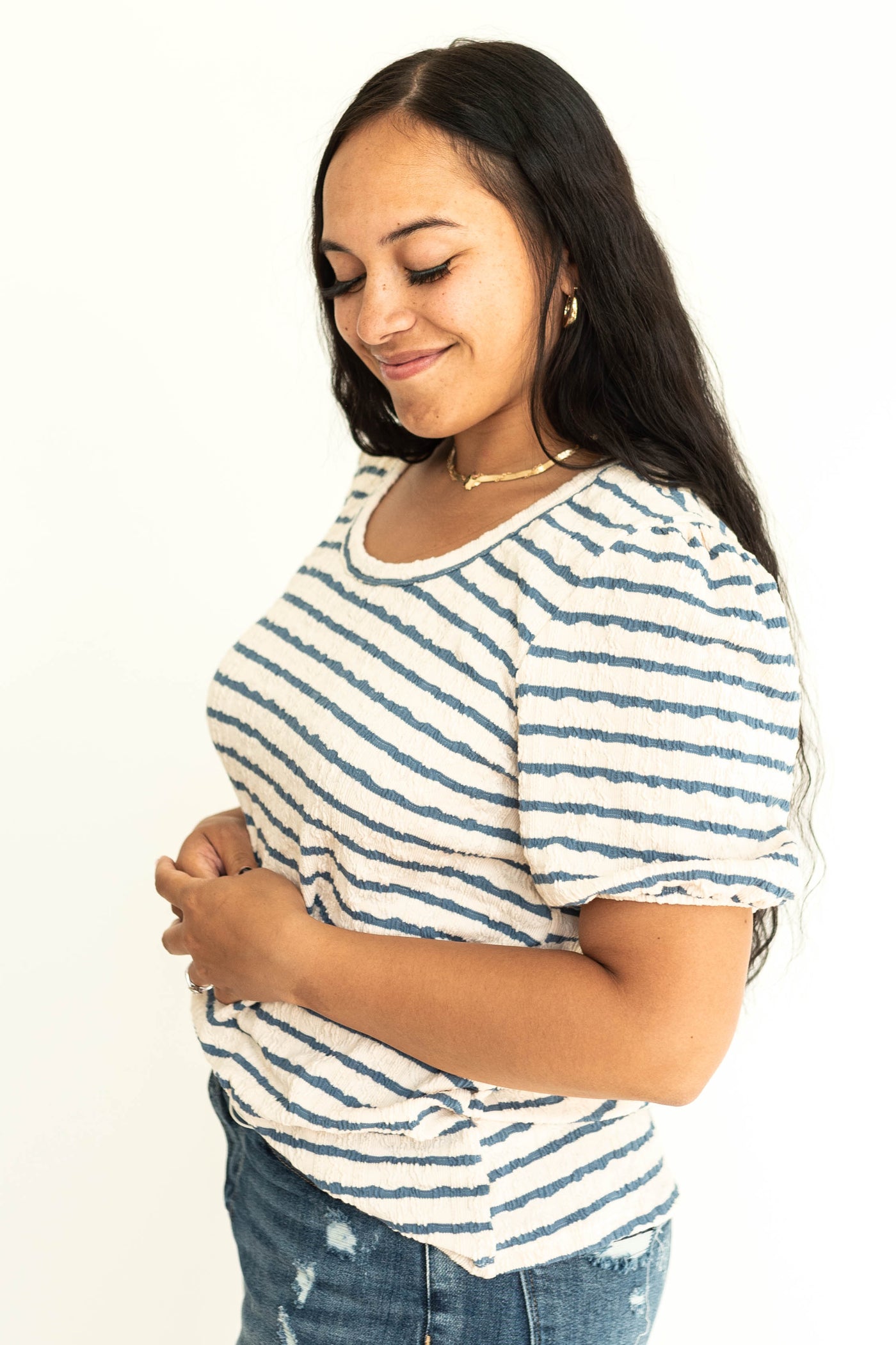 side view of an ivory and blue stripe top.