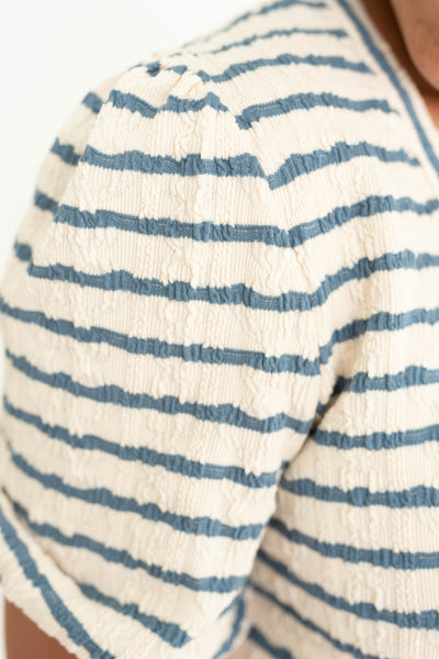 Sleeve view of a short sleeve blue stripe top.