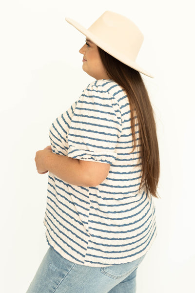 Side view of a plus size blue striped top with full sleeves
