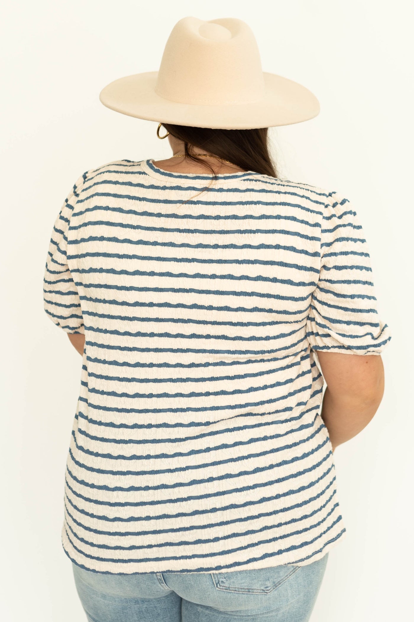 Back view of a plus size blue striped top with full sleeves 
