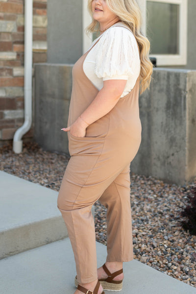 Side view of a plus size taupe jumpsuit
