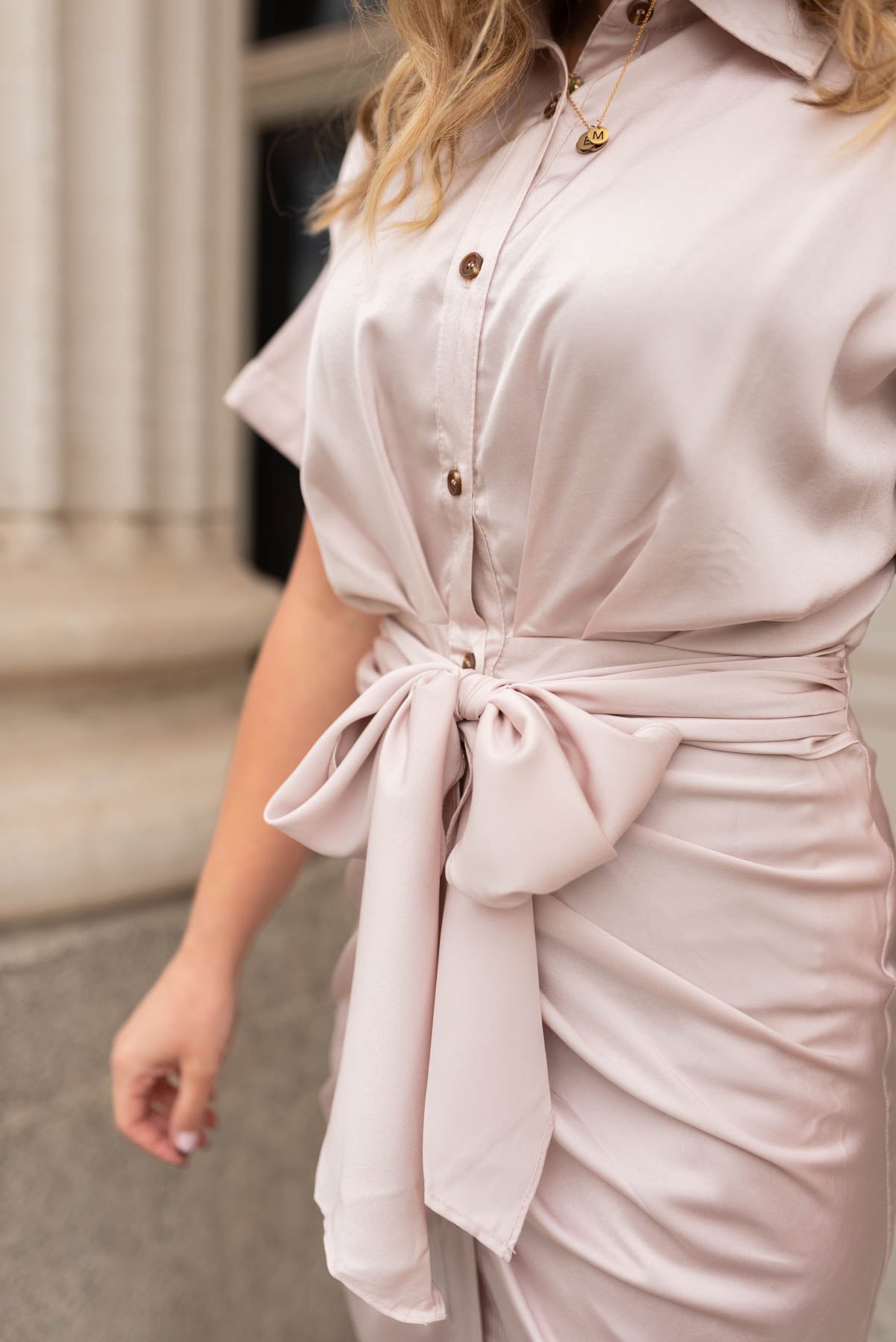 Close up of the rushing on the front of the champagne satin dress