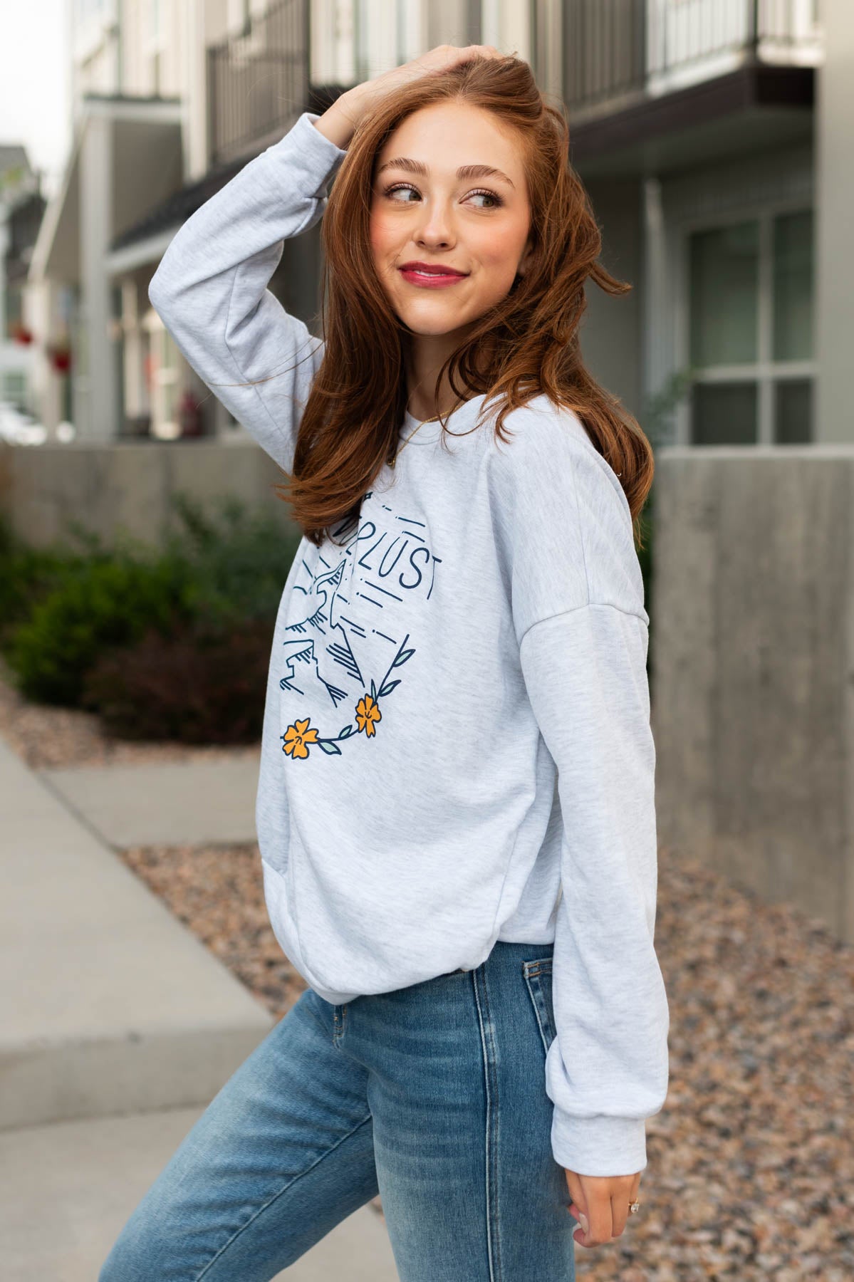 Side view of a long sleeve wanderlust grey pullover