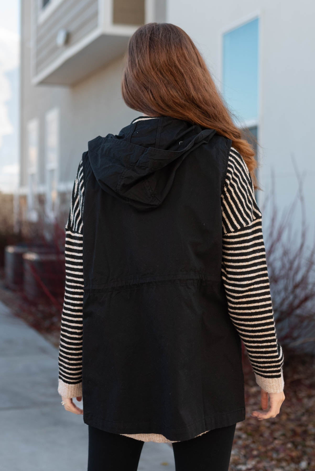 Back view of a black hooded vest