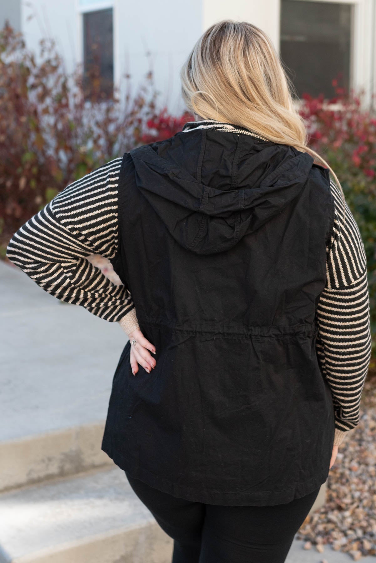 Back view of a plus size black hooded vest