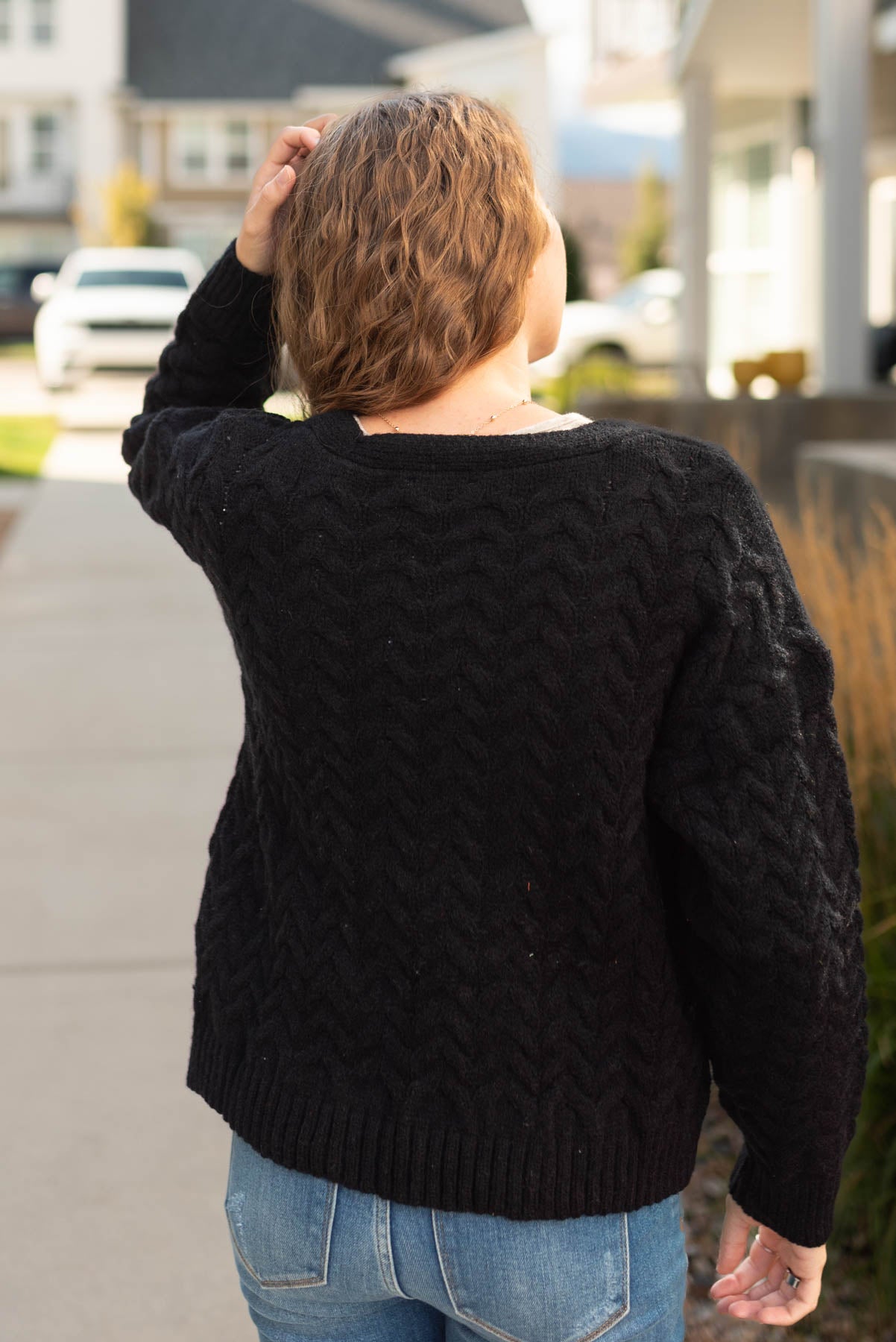 Back view of a black open knit sweater
