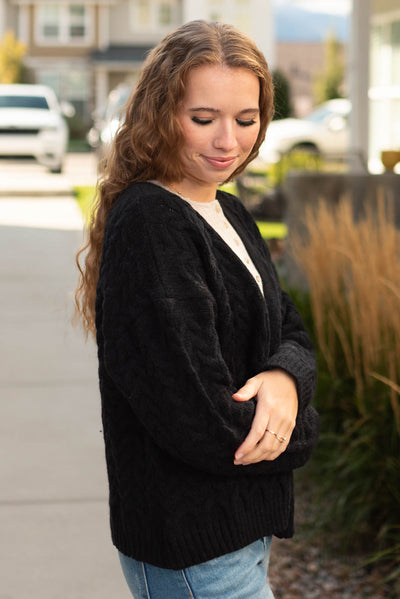 Side view of a black open knit sweater