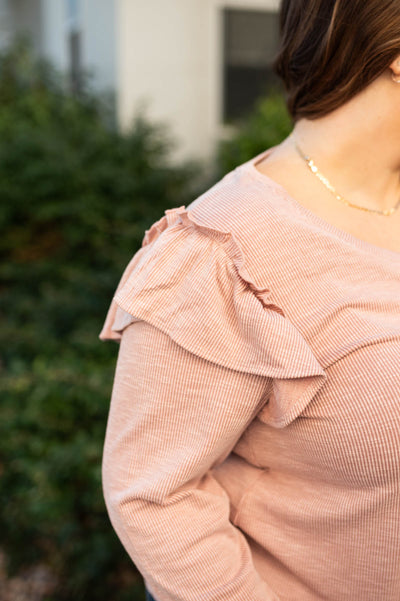 The ruffle at the sleeve of a plus size mauve top