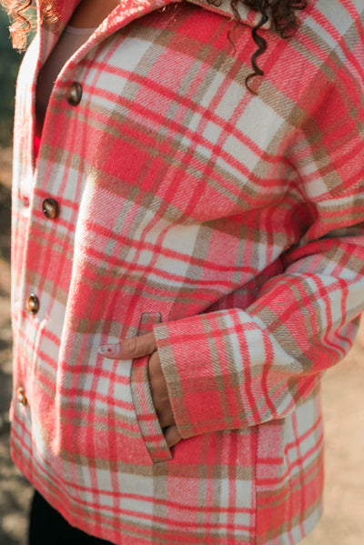 Close up on the fabric on a coral plaid shacket