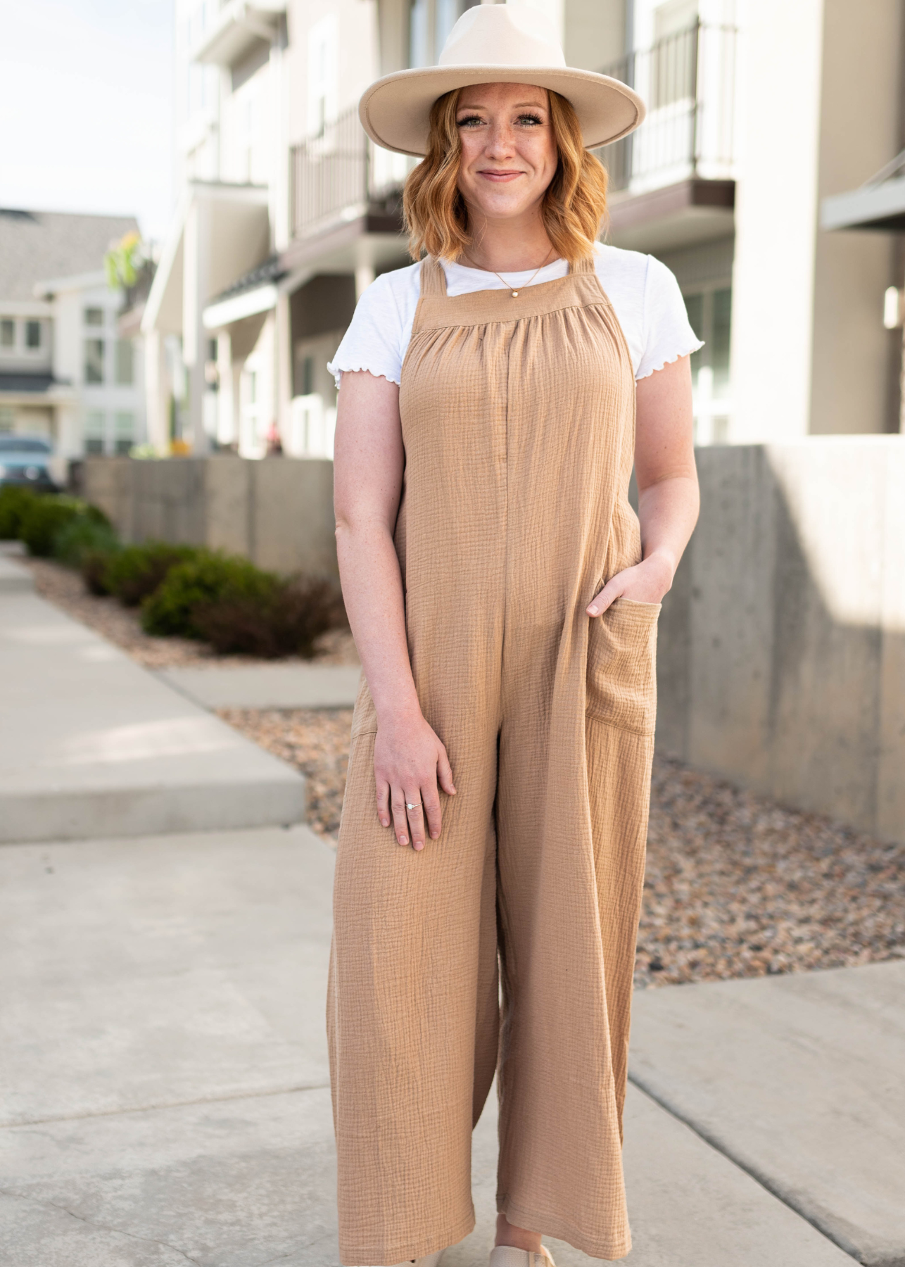 Taupe wide leg jumpsuit with pocket and tie in back.