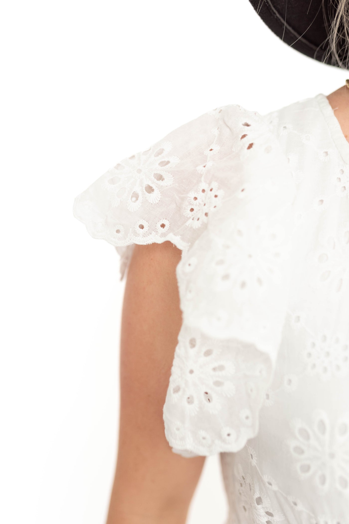 Sleeve of a white eyelet dress