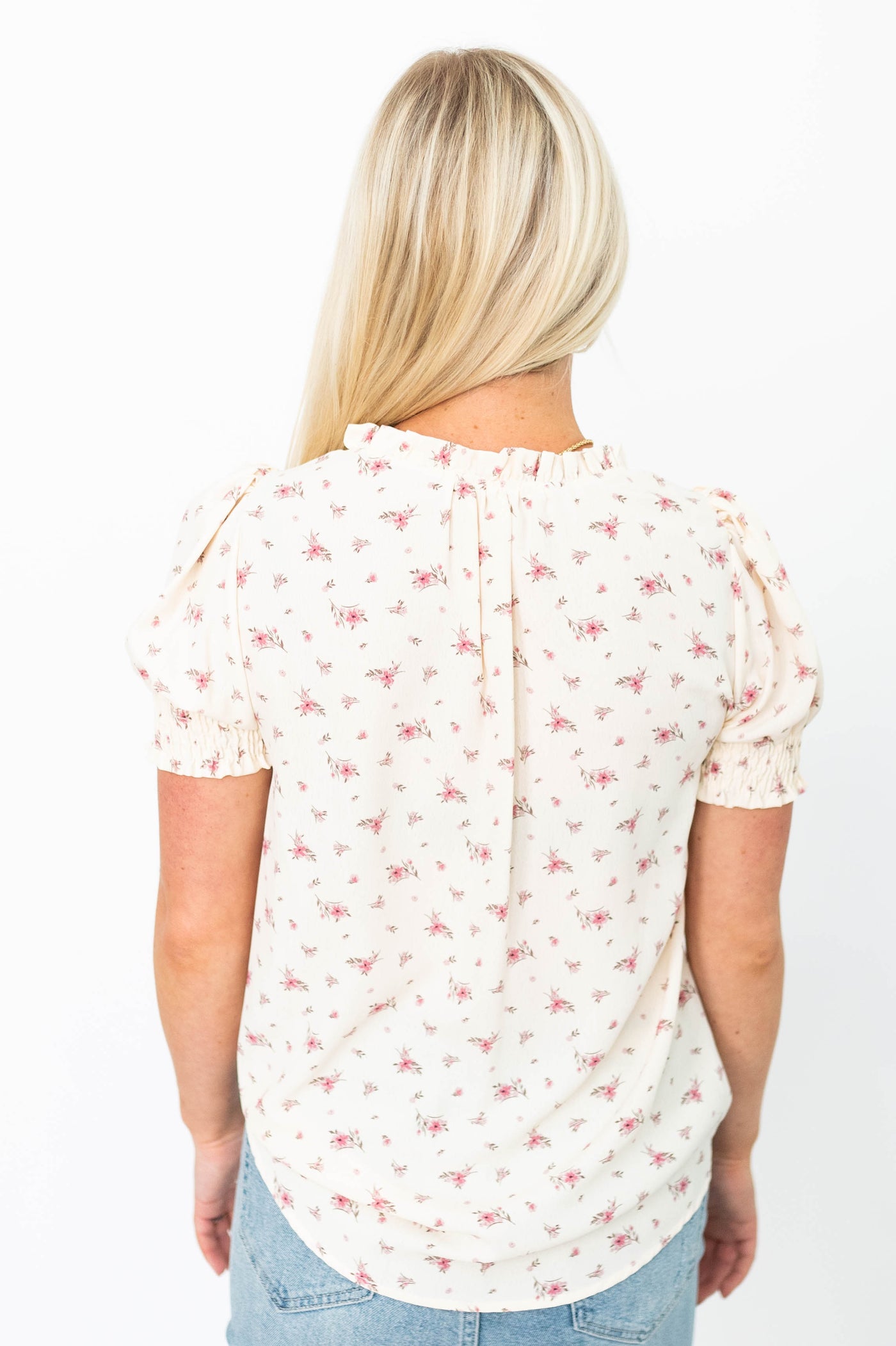 Back view of a cream floral top