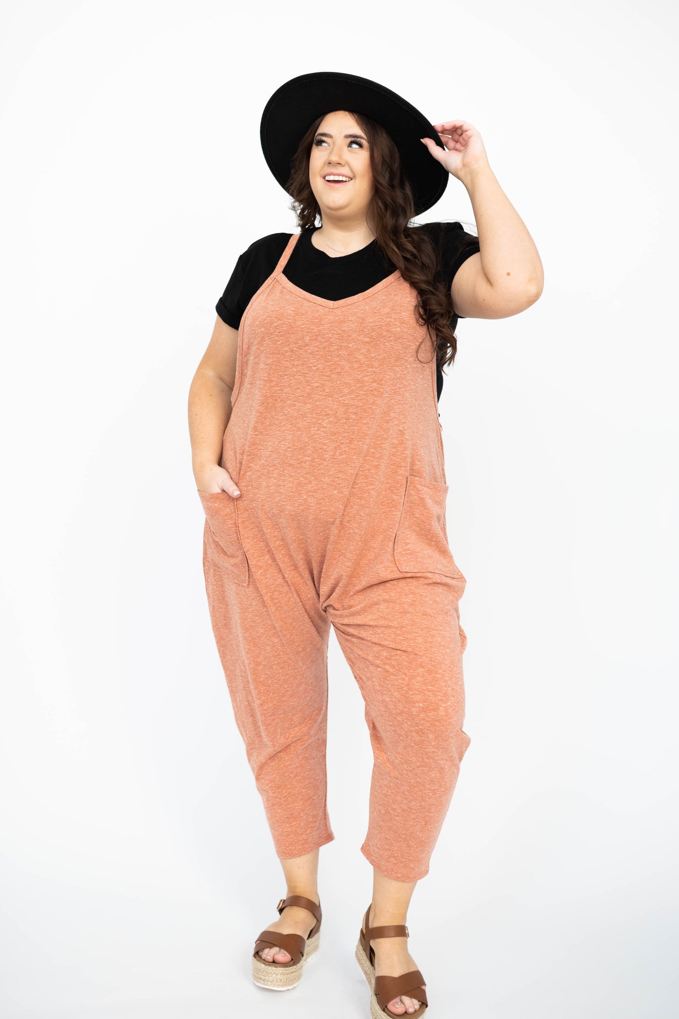 Plus size rust jumpsuit with pockets, tapered legs and v-neck