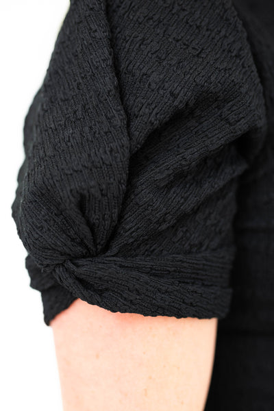 The sleeve of a black top