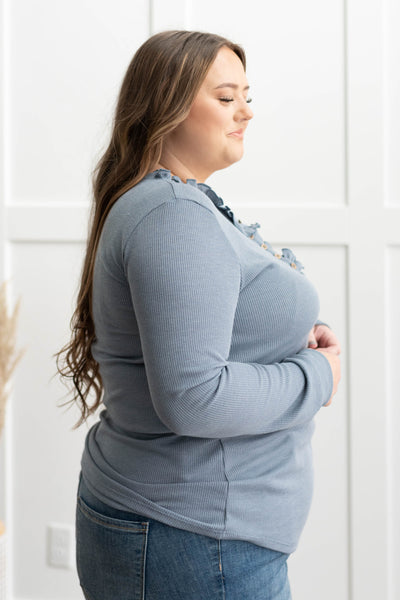 Side view of a plus size blue knit top