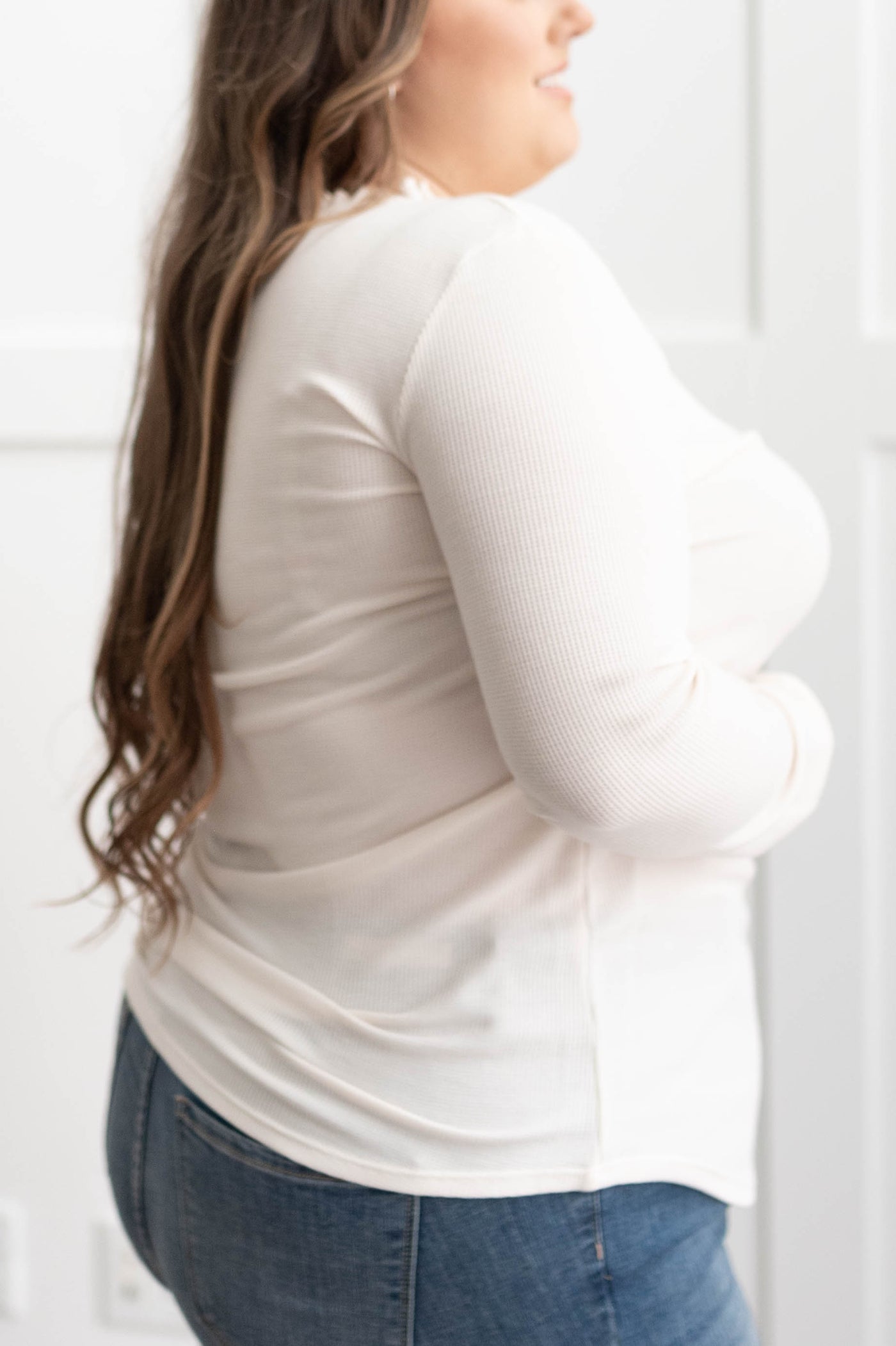 Side view of a plus size cream knit top