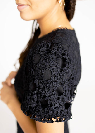 Sleeve view of a black lace dress