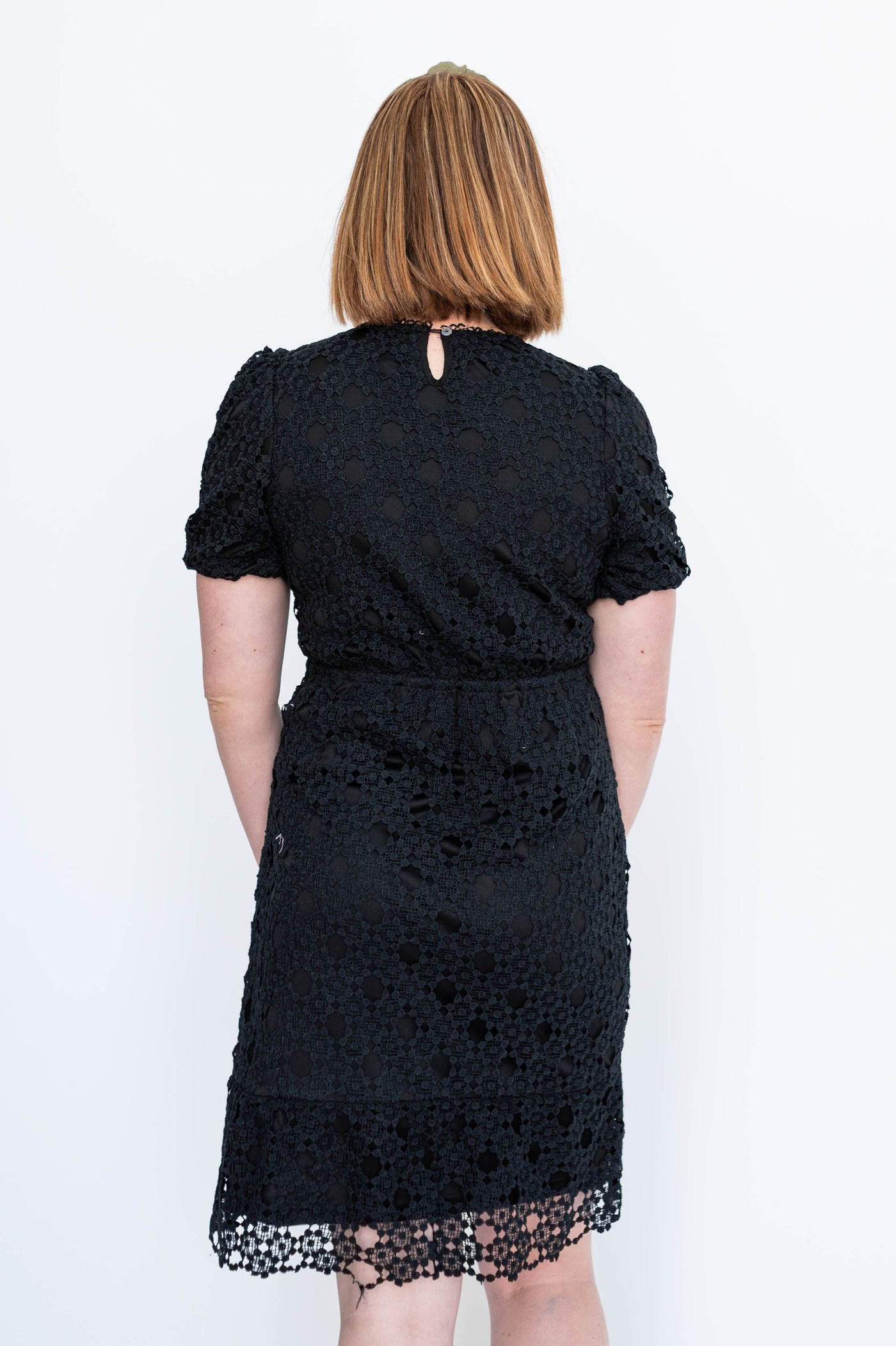 Back view of a short sleeve black lace dress