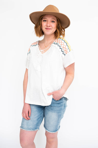 Short sleeve white top with cross stitch detail on the shoulders