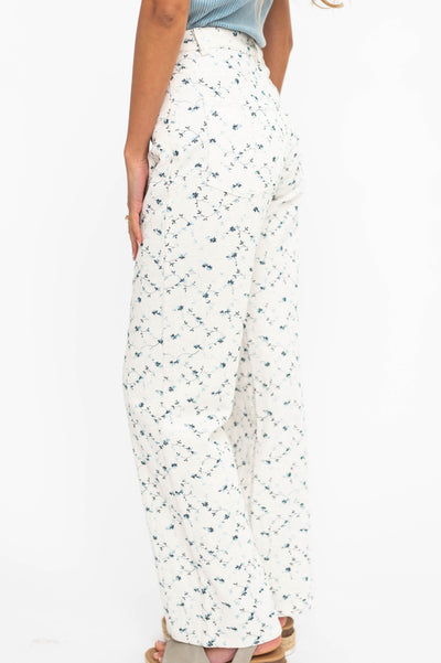 Side view of ivory floral pants with blue flowers