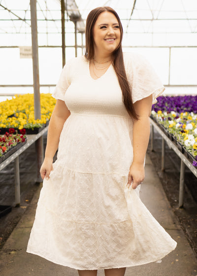 Plus size cream dress with pockets, smocked bodice and short sleeves