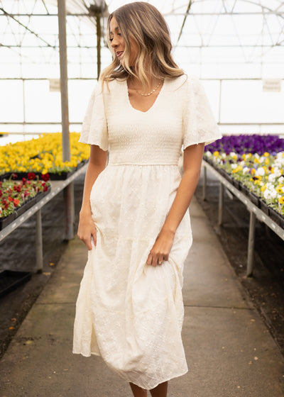 Side view of a short sleeve cream dress with pockets