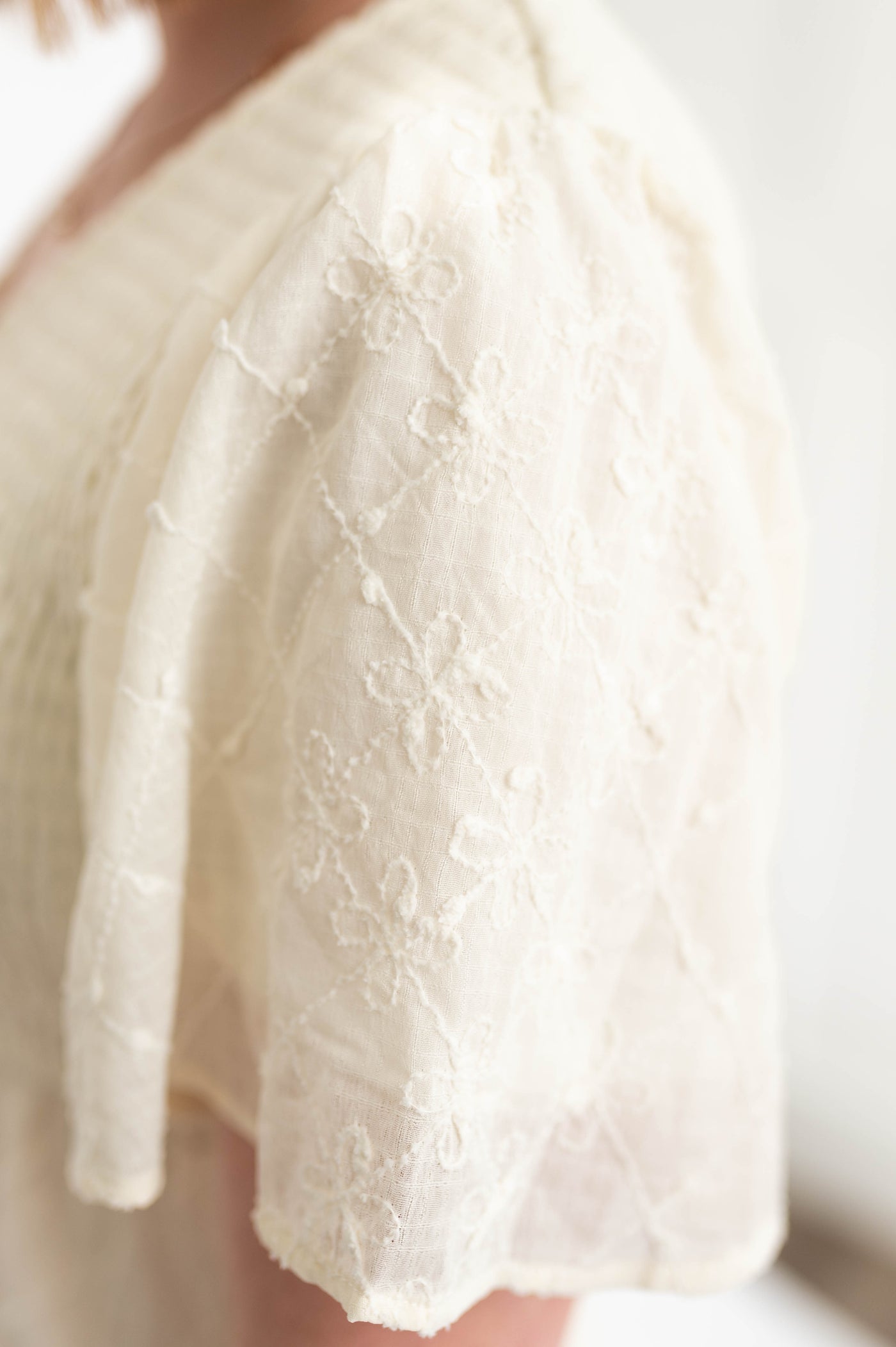 Sleeve of a cream dress