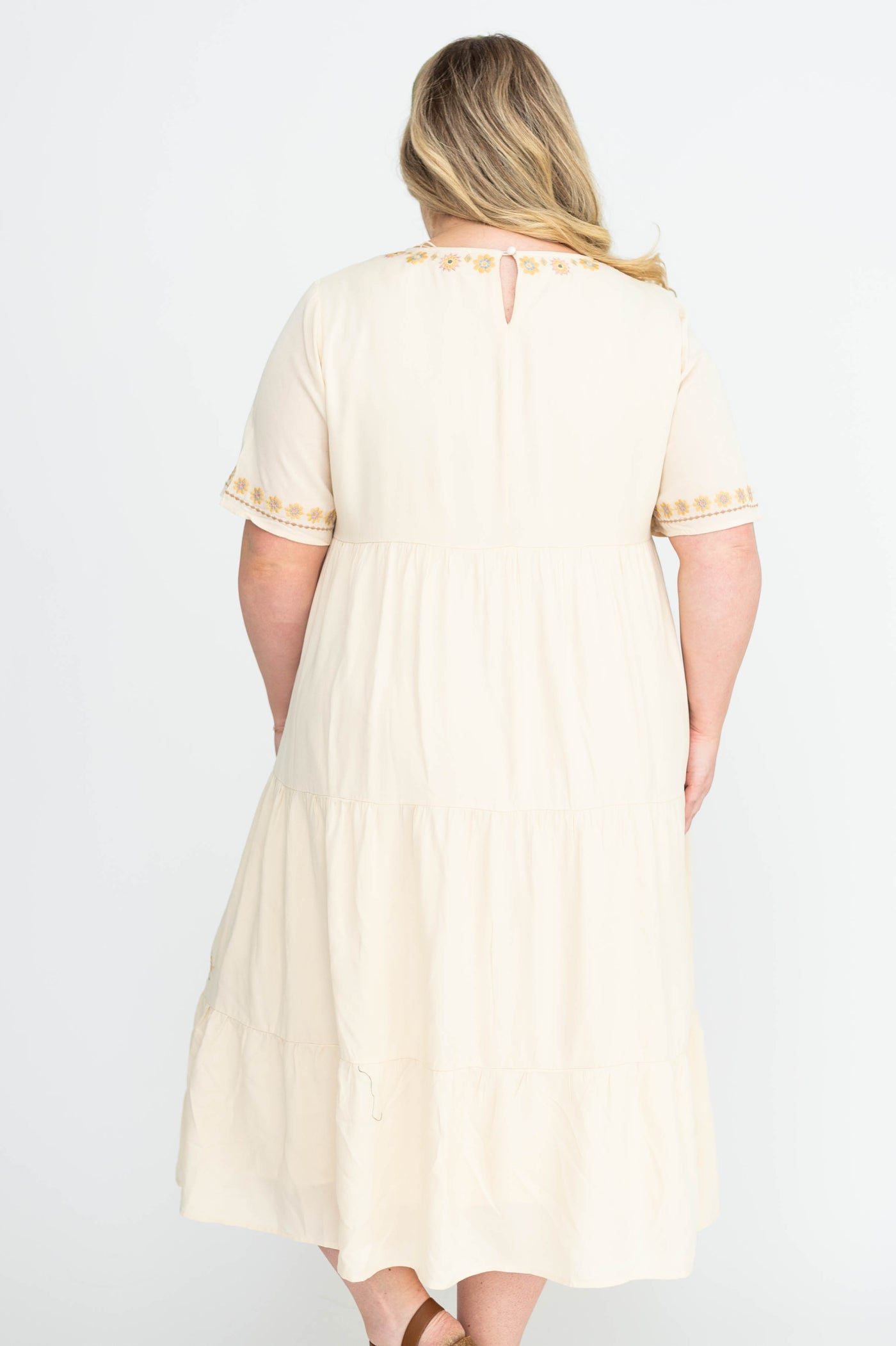 Back view of a plus size cream dress