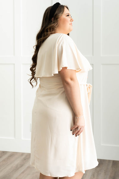 Side view of a plus size cream dress