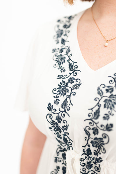 Navy embroidery on a white dress