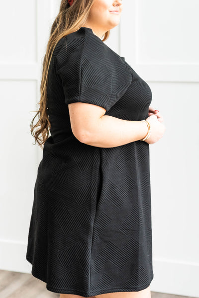 Side view of a plus size black textured dress