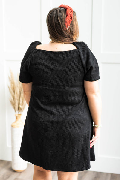 Back view of a plus size black textured dress