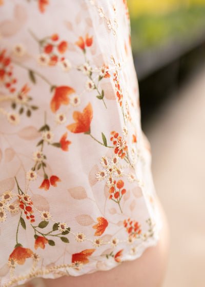 Close up of the sleeve of a plus size cream floral dress