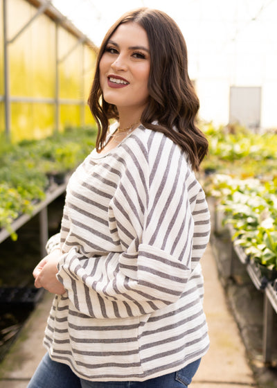 Side view of a plus size heather grey top with a drop shoulder