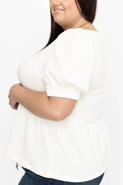Side view of a plus size ivory top