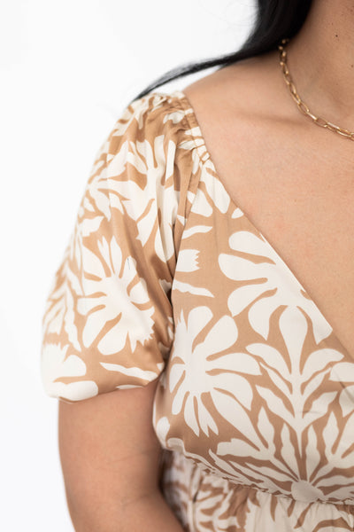 The sleeve of a taupe floral dress