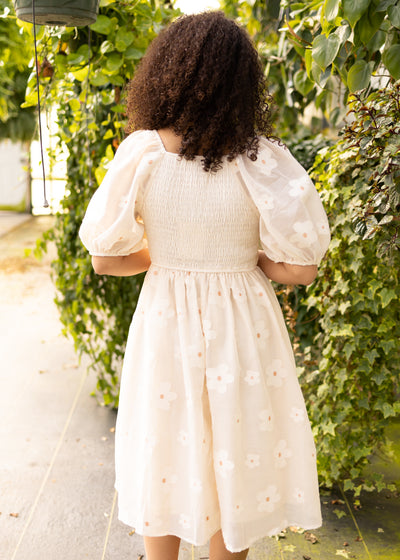 Back view of a cream floral dress