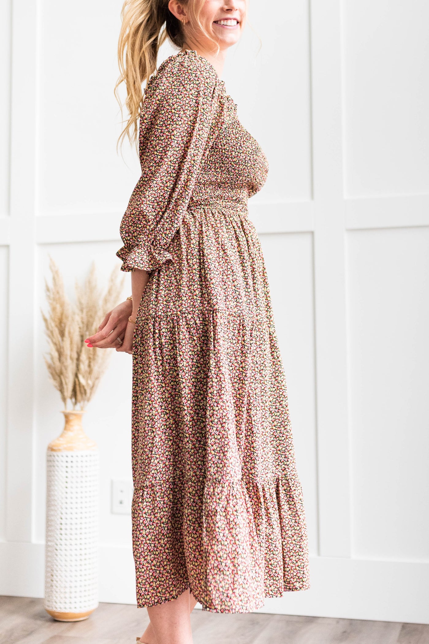 Side view of a black floral dress with a smocked bodice