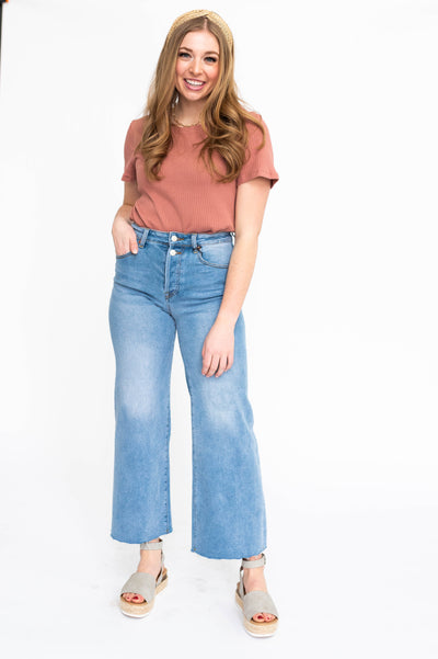 Wide leg light indigo jeans with fading on legs, frayed hem and pockets