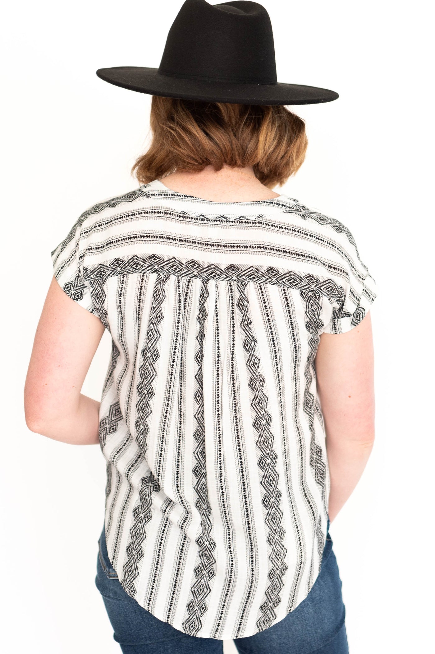 Back view of a short sleeve white top with black pattern