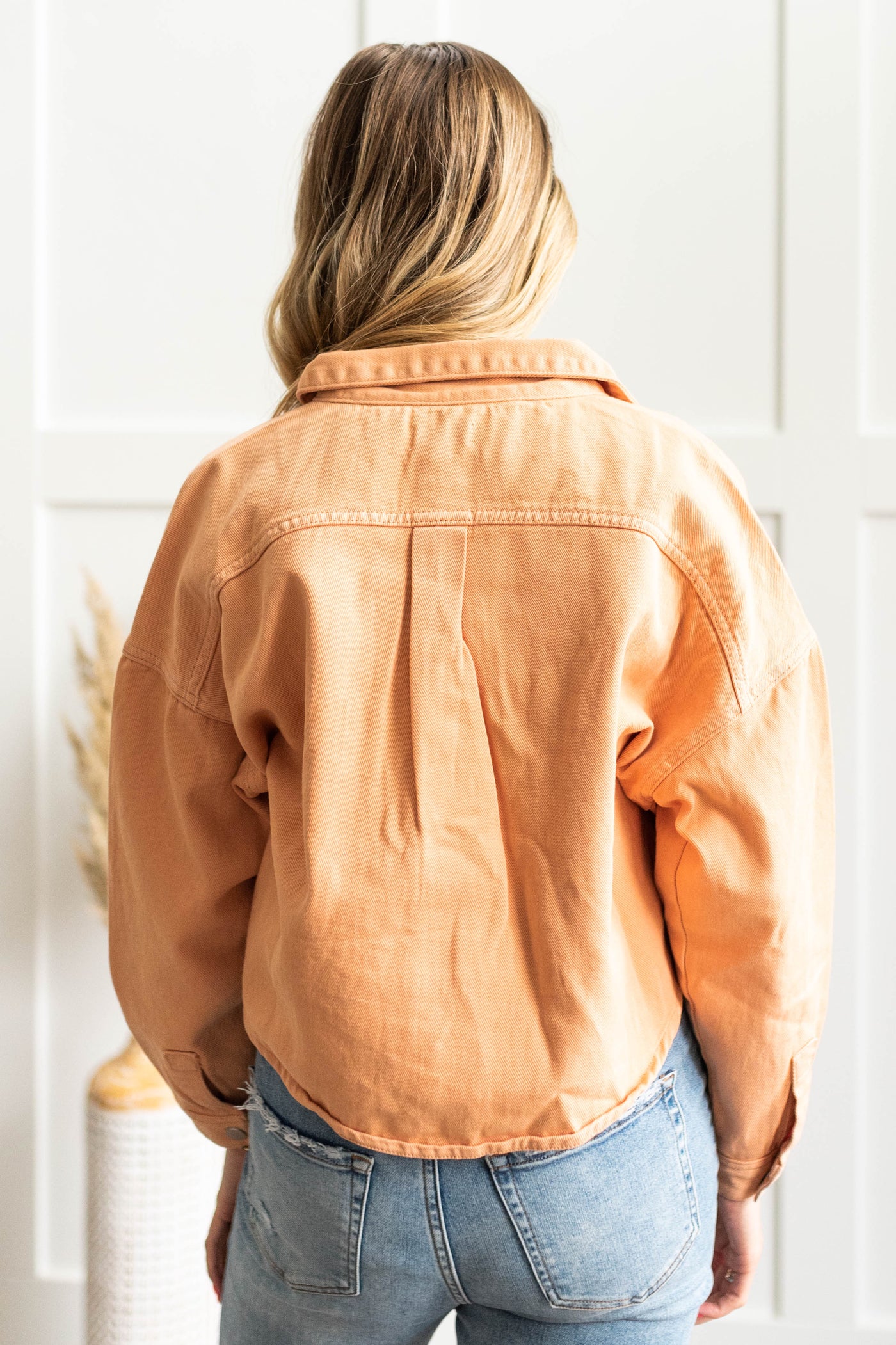 Back view of a orange jean jacket