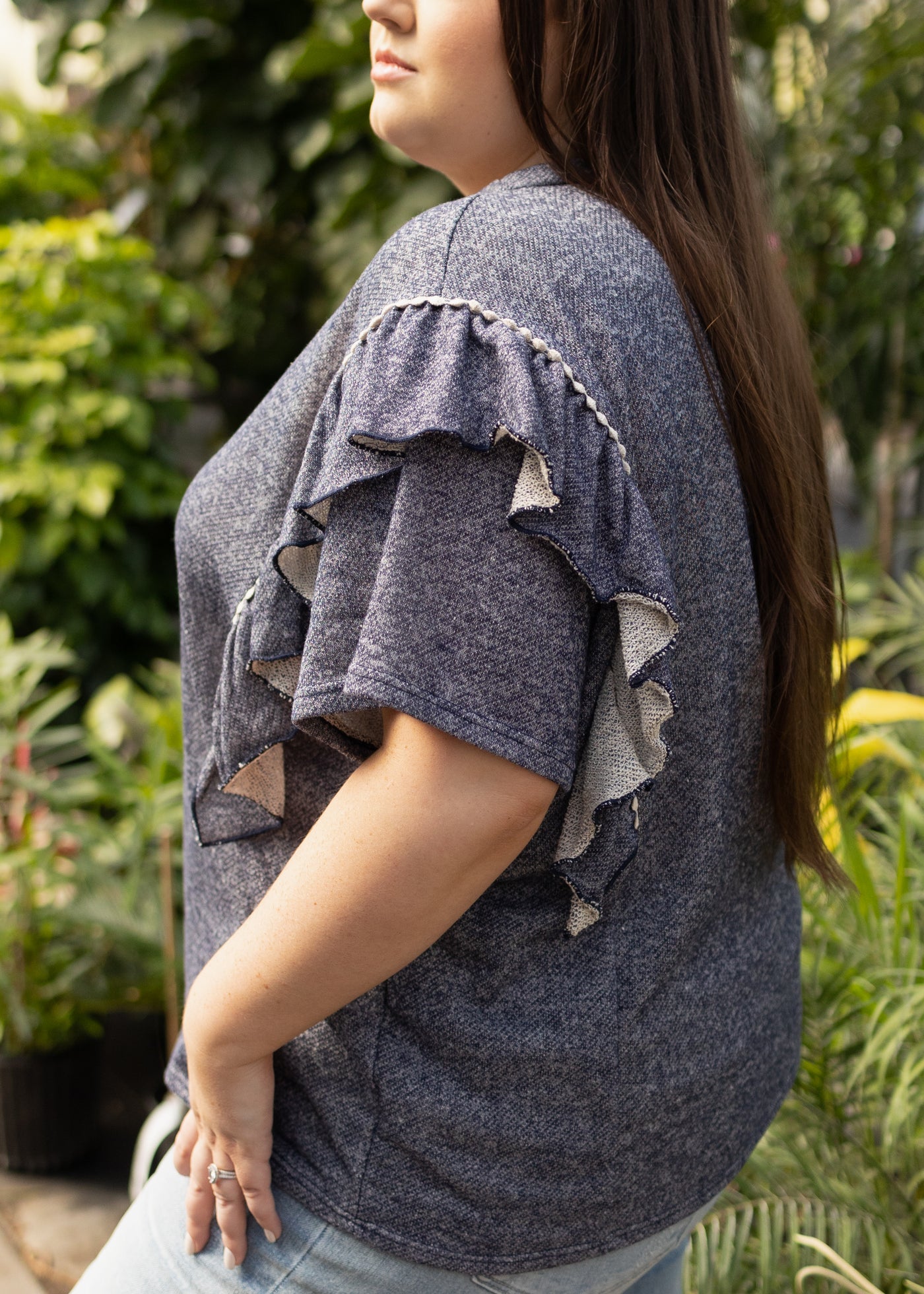Side view of a plus size denim top with ruffles