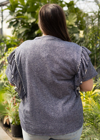 Back view of a plus size denim blue top