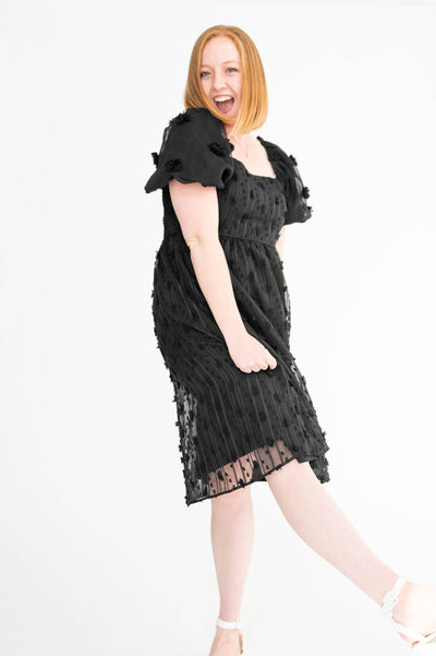 Front view of a medium black dress with short sleeves