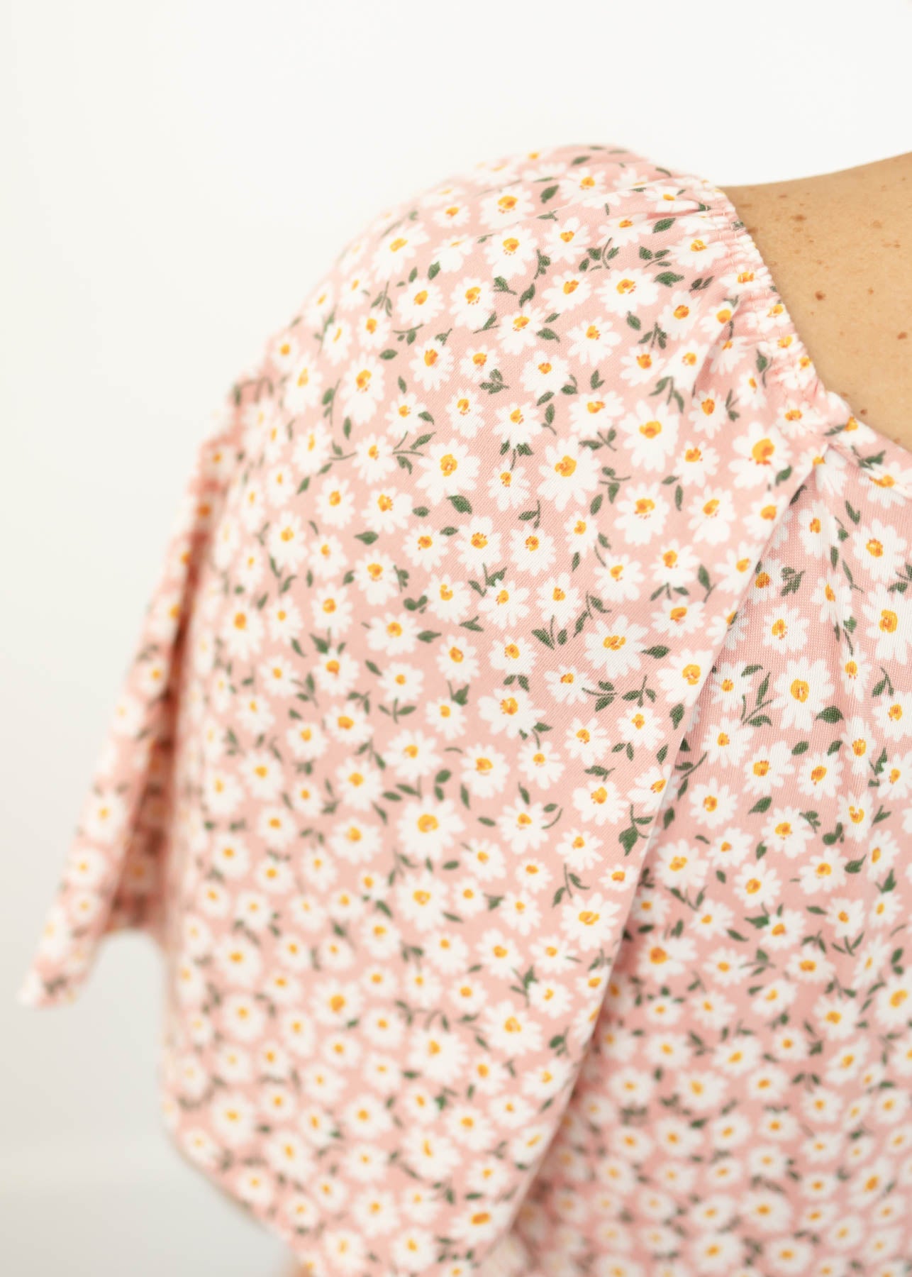 The sleeve of a blush floral dress