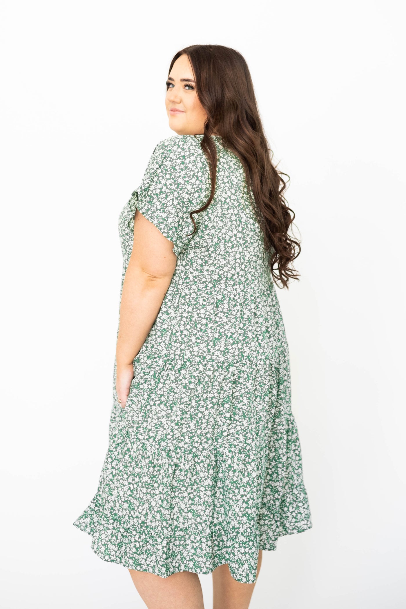 Side view of a plus size green floral dress