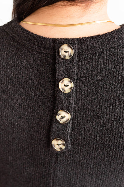 Buttons on the back of a black top